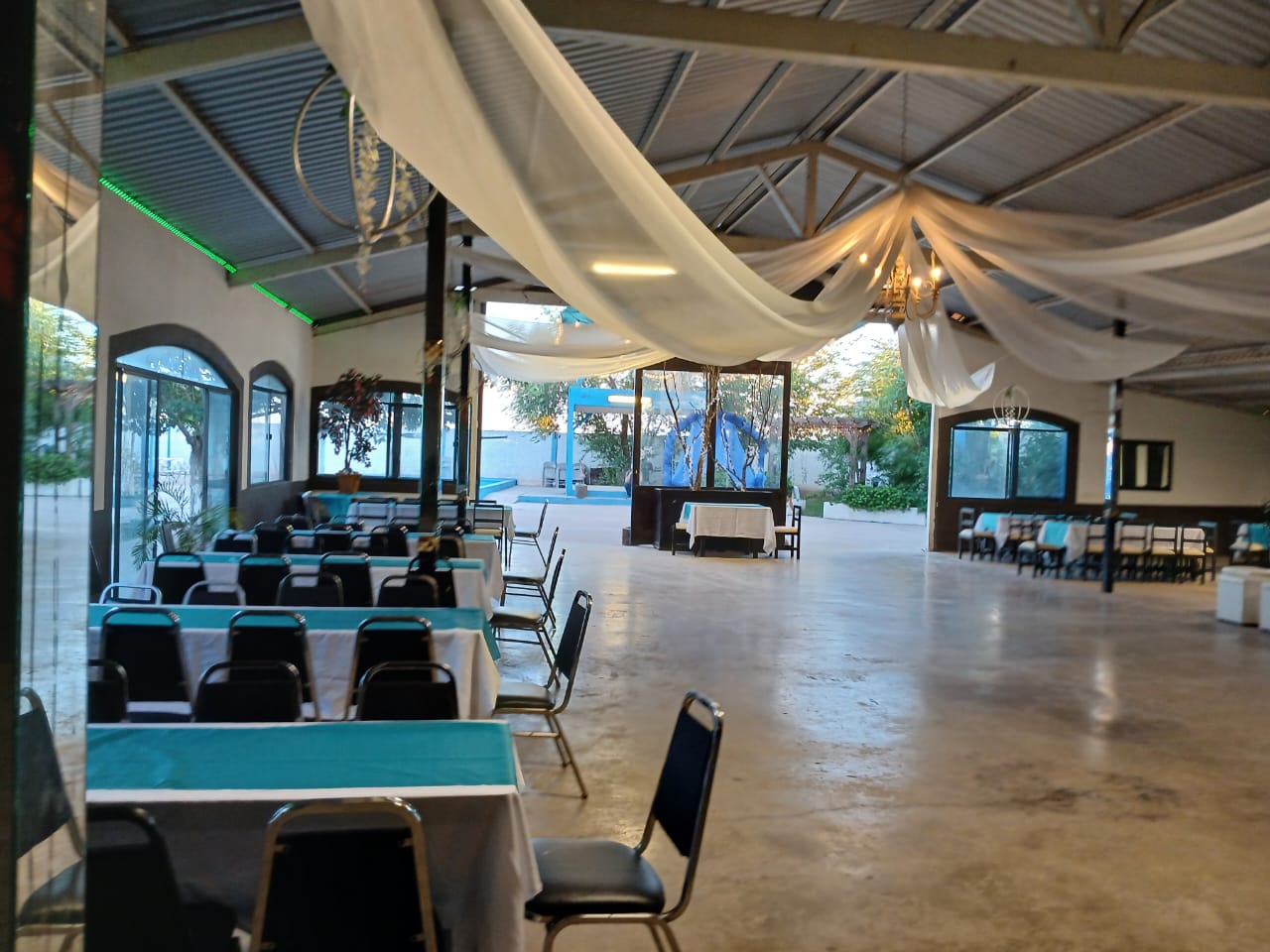 Interior del salón con mesas, sillas y decoración